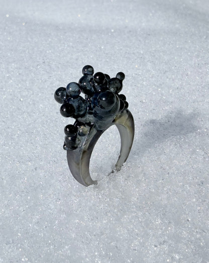 High-fashion styling with a black architectural ring, perfect for gallery openings or artistic events
