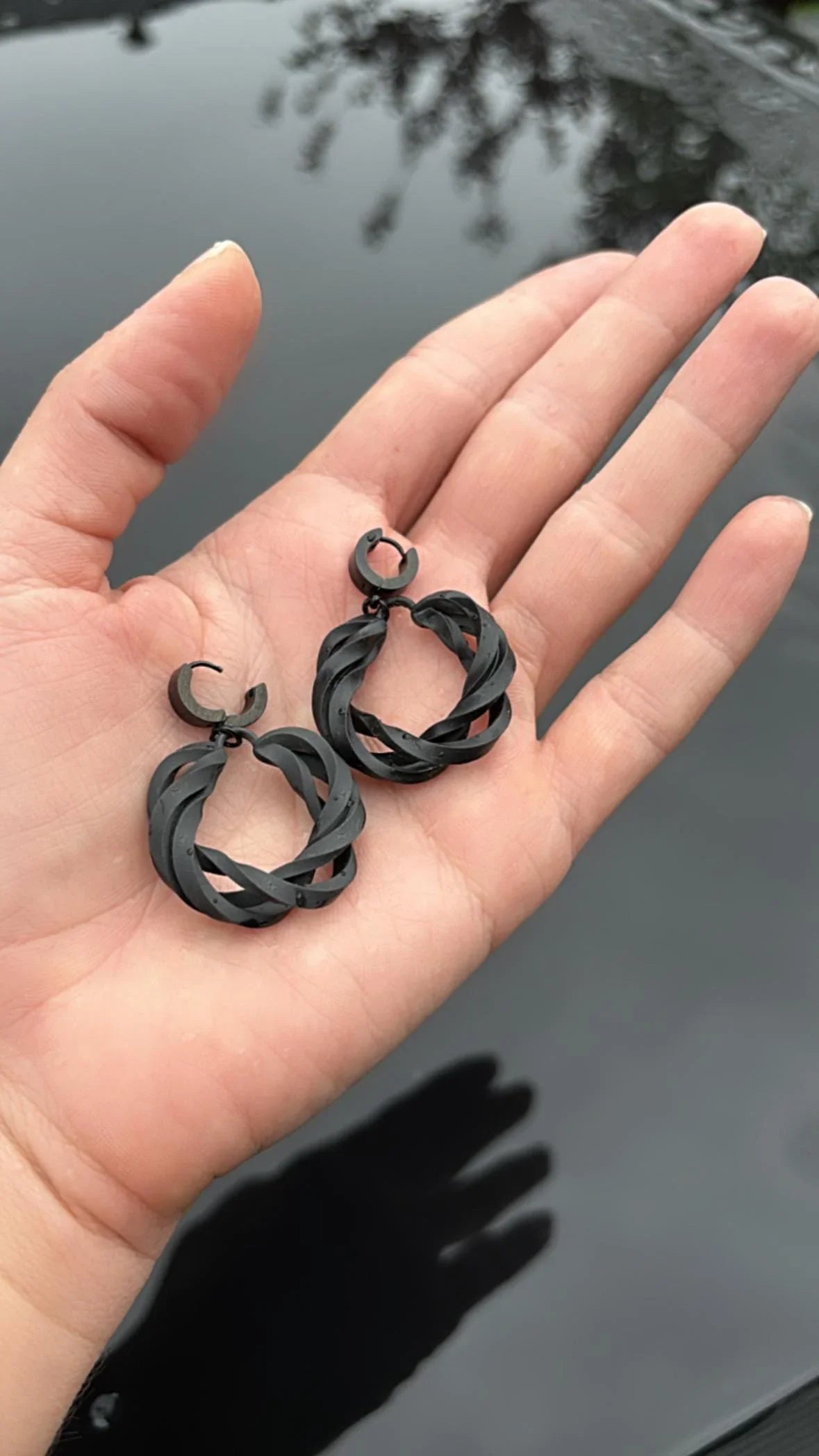 Chunky black jewellery on hand, showing the lightweight and scale of the design.