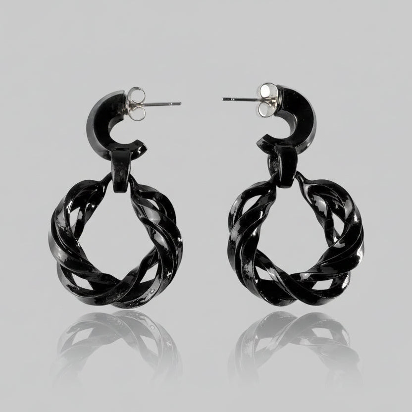 Pair of black fashion jewelry infinity hoops on a white background.