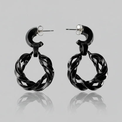 Pair of black fashion jewelry infinity hoops on a white background.