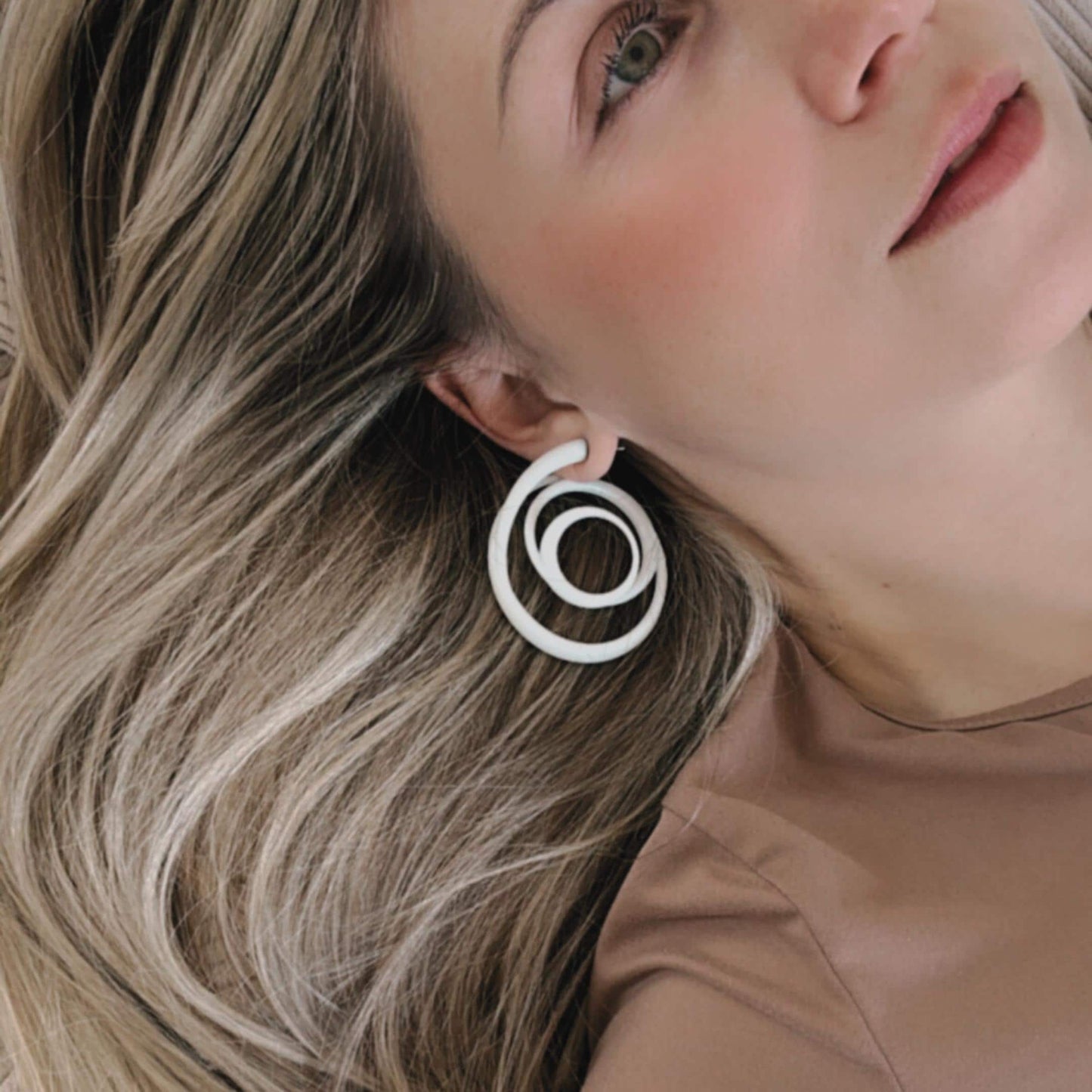 Final close-up of modernist statement earrings demonstrating fit and finish.