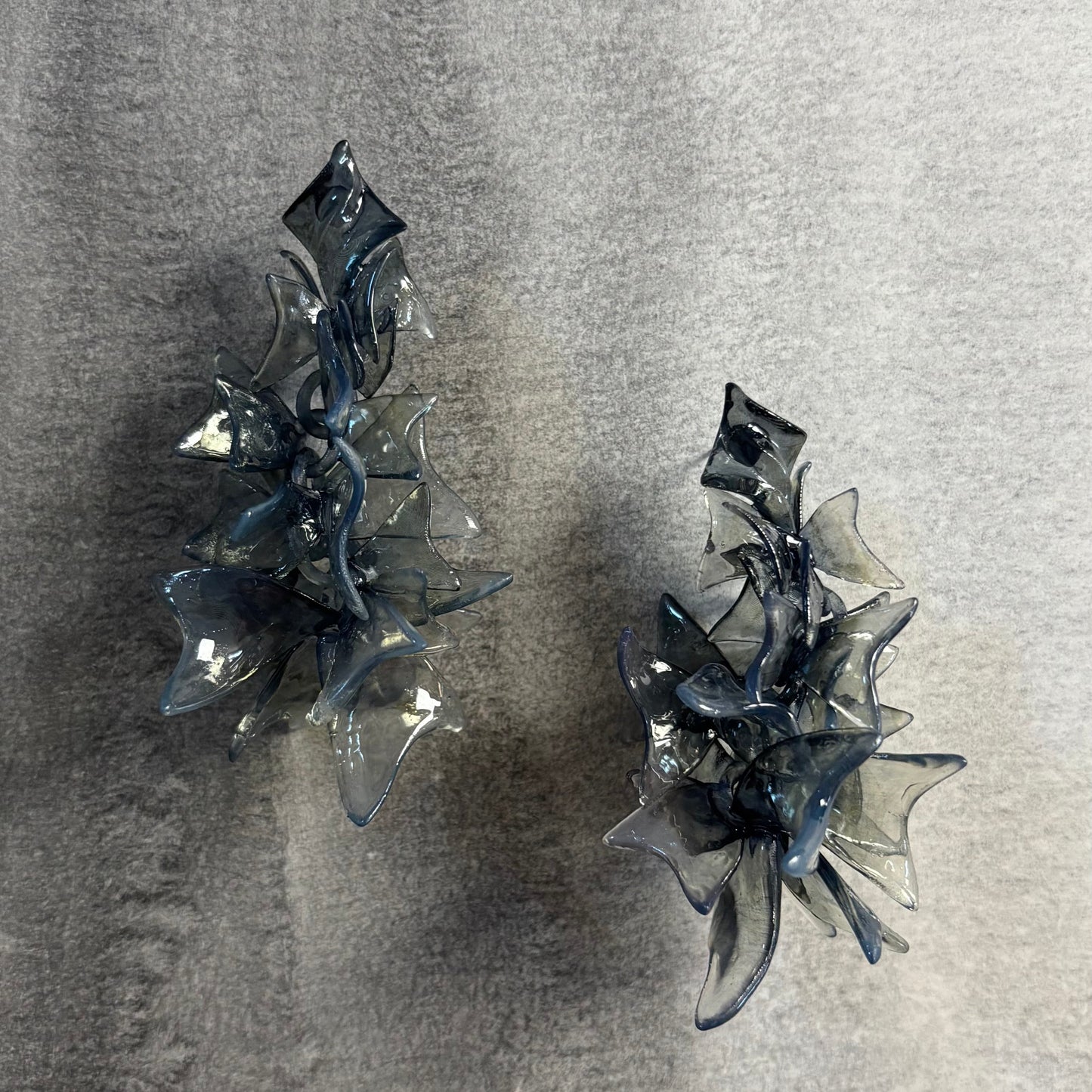 Chunky black jewellery petals on a neutral background, showing flow.