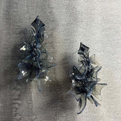 Chunky black jewellery petals on a neutral background, showing flow.