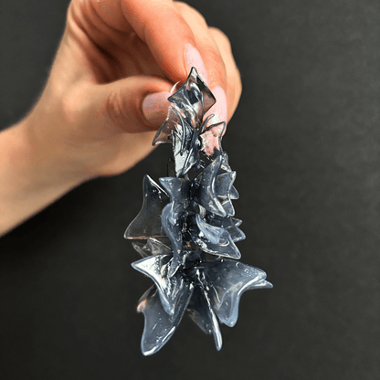 Hand holding bold statement earrings, highlighting the lightweight design.