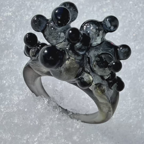 Cinematic video of the Dark Matter sculptural ring, showing the 3D organic form and light reflecting off the glossy surfaces.