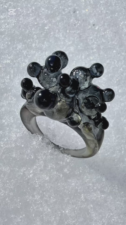 Cinematic video of the Dark Matter sculptural ring, showing the 3D organic form and light reflecting off the glossy surfaces.