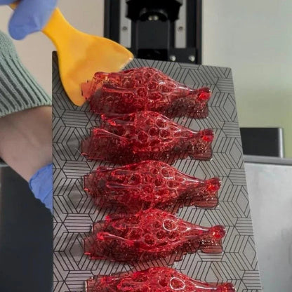 Raw 3d printed statement jewelry (red drip earrings) fresh off the printer, showing the initial creation process