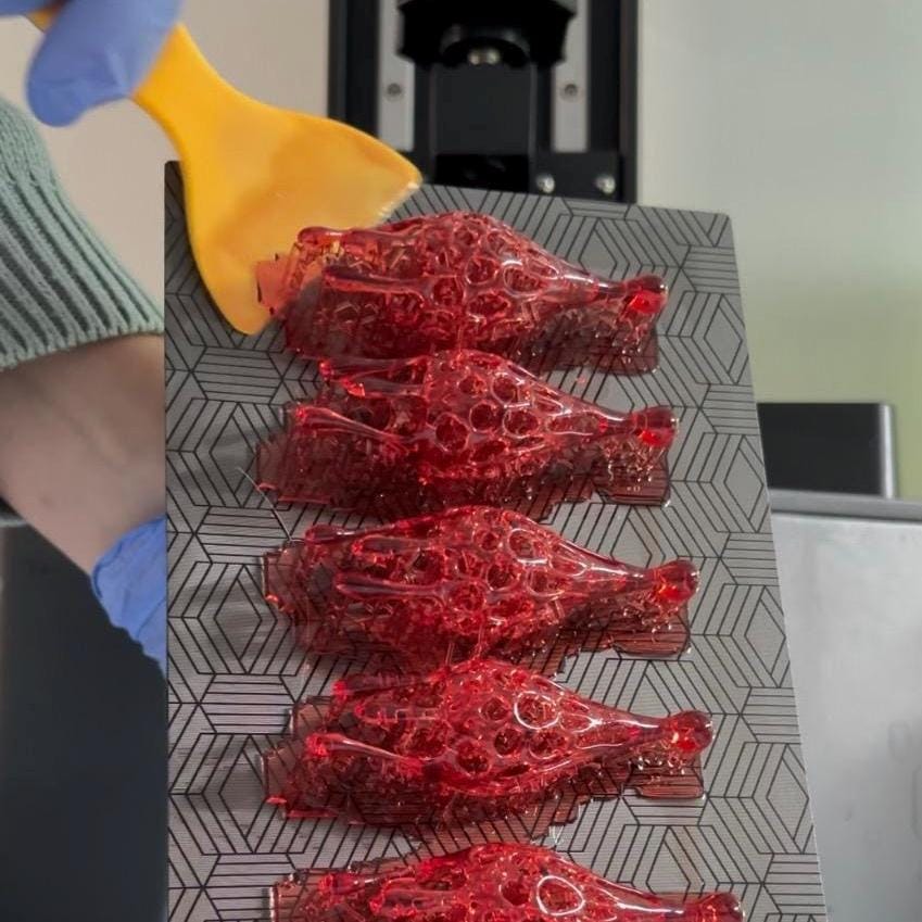 red drop statement 3d printed earrings on a gray surface.