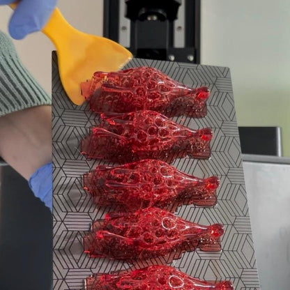 red drop statement 3d printed earrings on a gray surface.