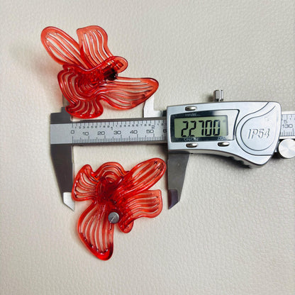 Pair of Cherry Red Rhythm earrings next to a measuring caliper to show size and scale