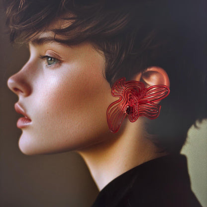 Close-up model shot of Cherry Red Rhythm earrings, dark background, side profile