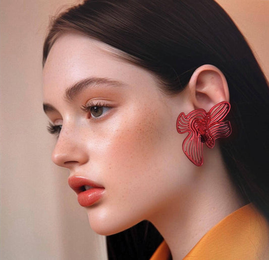 Model wearing bright Cherry Red Rhythm earrings, front/side profile view