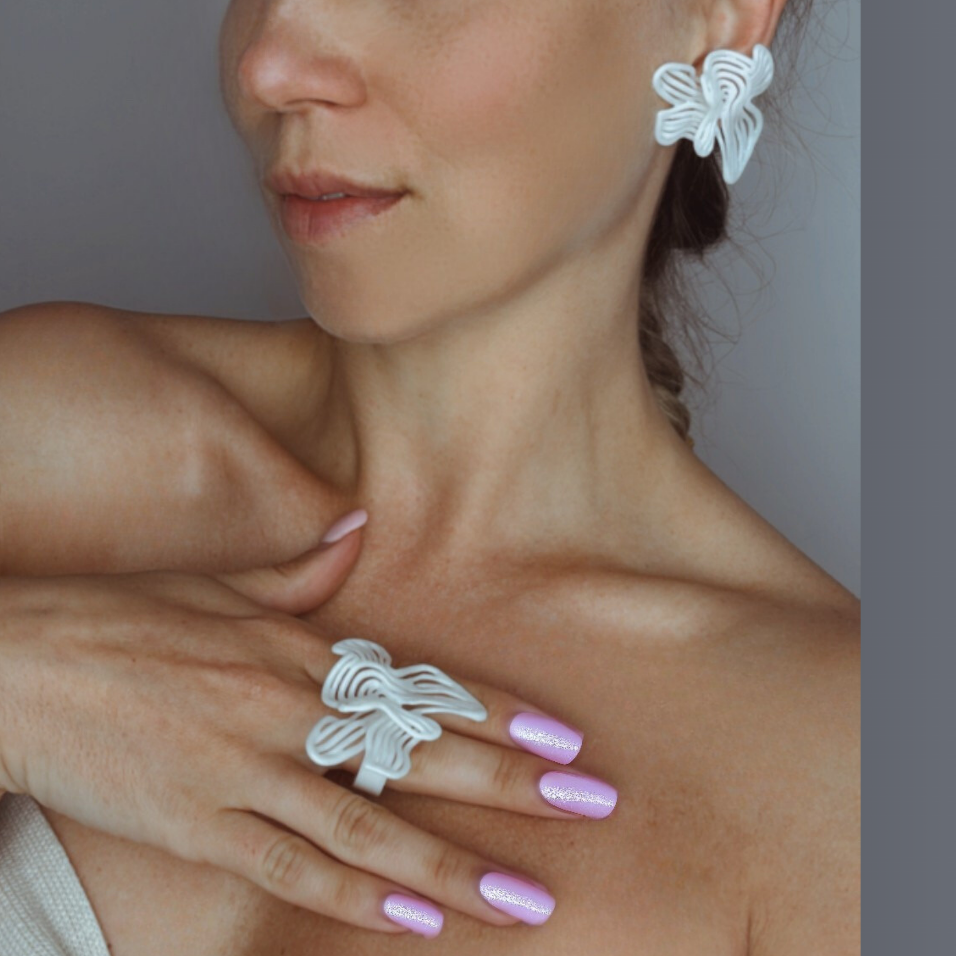 Model with hand on chest showing the statement Rhythm White earrings and ring