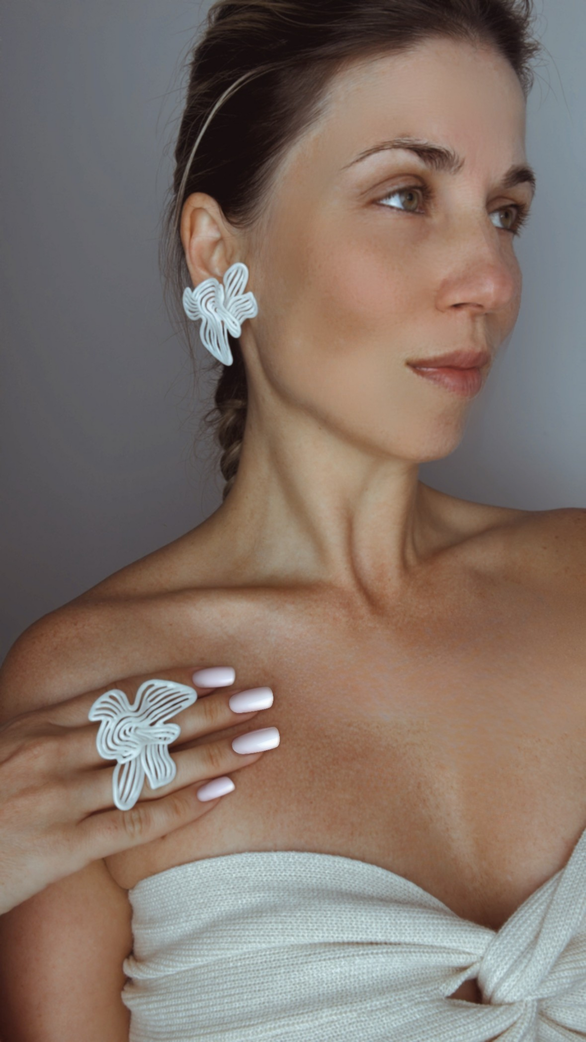 Side profile of model wearing Rhythm White earrings and ring set, highlighting the texture