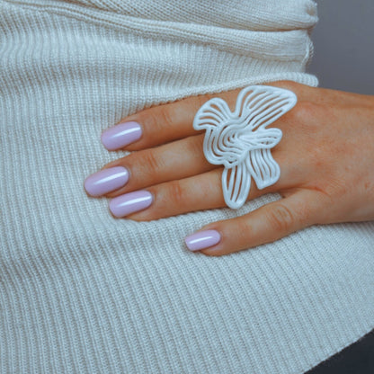 Close-up of model's hand wearing the intricate sculptural Rhythm White ring