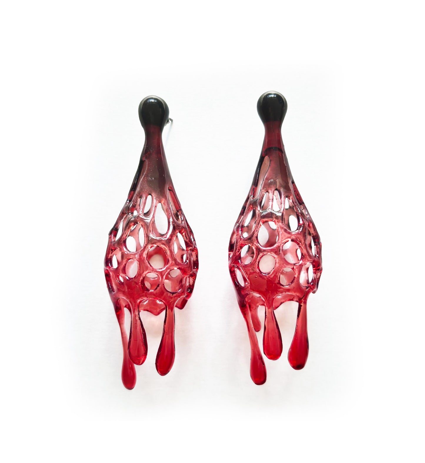 Pair of red and black earrings on a white background