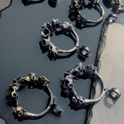 large black hoop earring with unique design on a dark surface