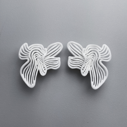 Two white floral-shaped 3d printed earrings on a gray background