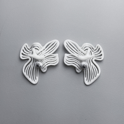 Pair of white white floral-shaped 3d printed earrings backs on a gray background