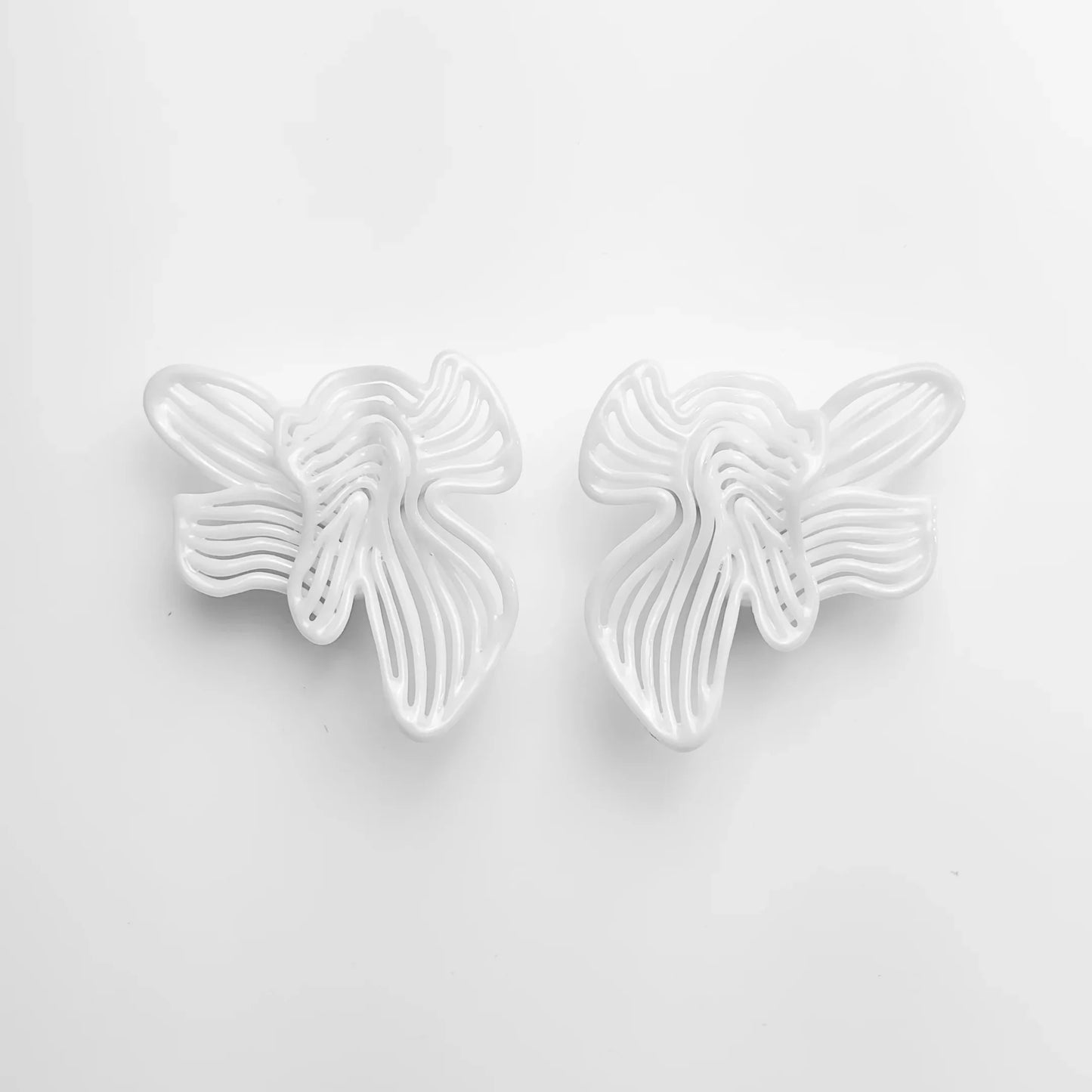 Frontal shot of the pair of bridal shower jewelry, showing the flowing sculptural design