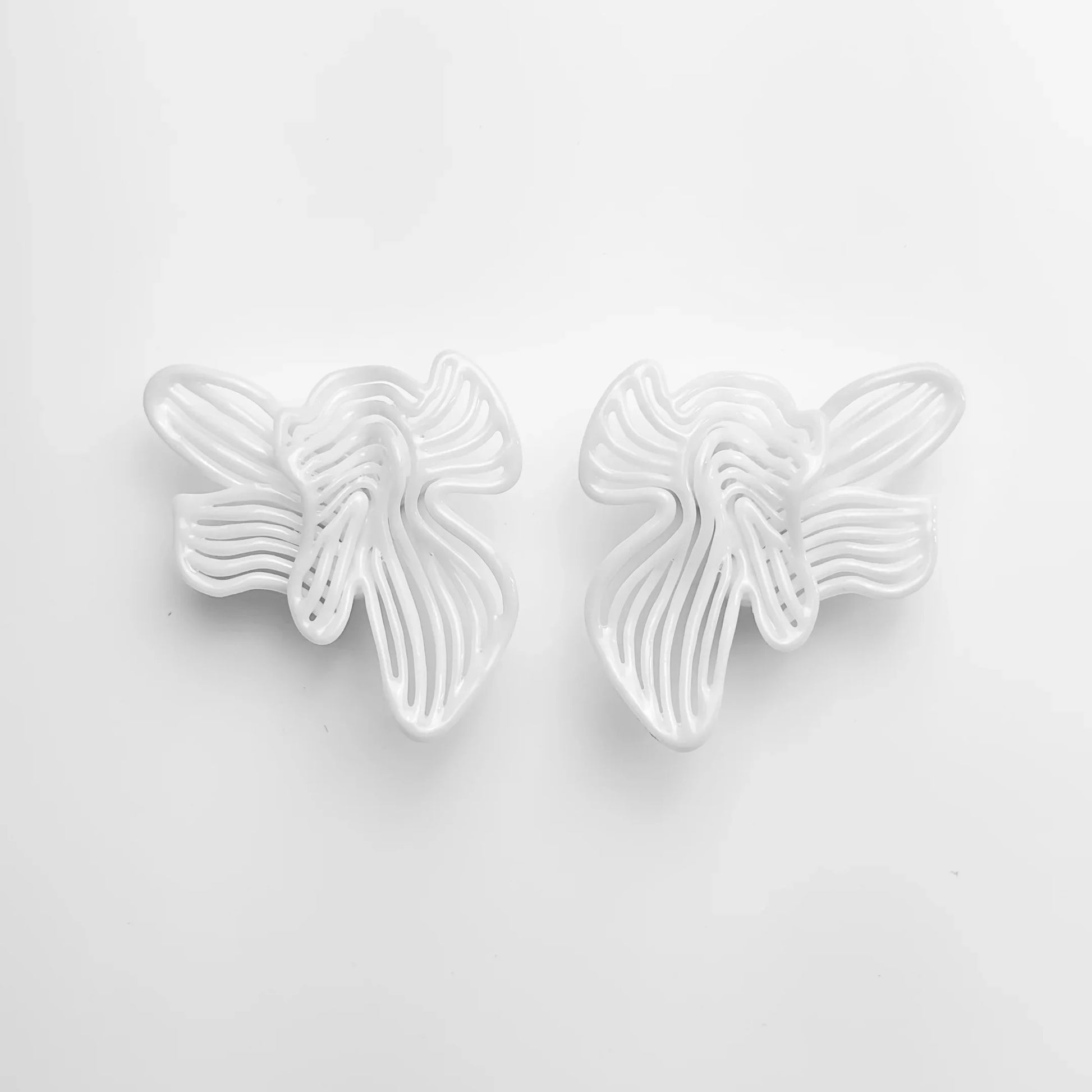 Frontal shot of the pair of bridal shower jewelry, showing the flowing sculptural design